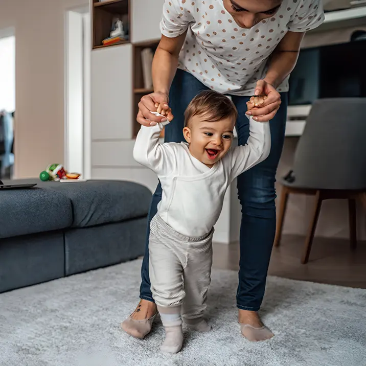 Baby learning to walk with adult help