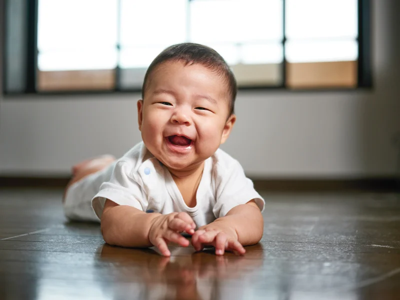 Happy baby smiling while lying on floor