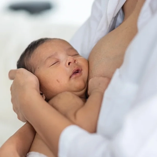 Newborn sleeping peacefully in mothers arms