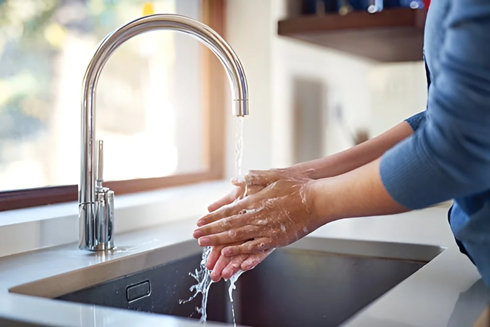 Hands being washed under running tap water
