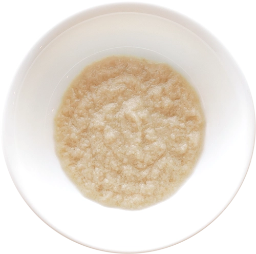 Bowl of smooth baby cereal on white background