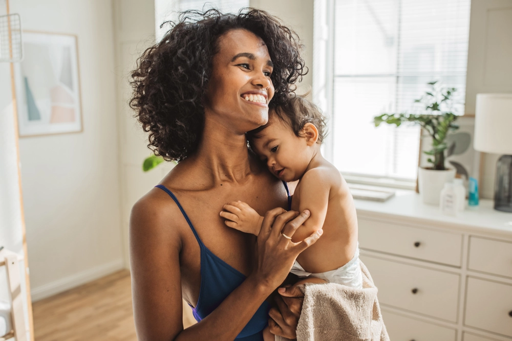 Smiling mom holding her baby indoors