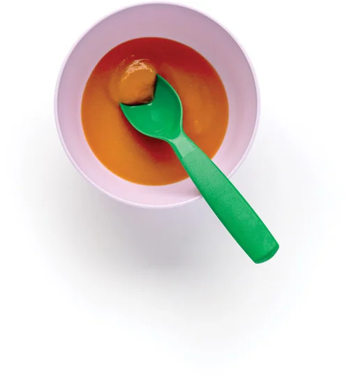 Bowl with sweet baby food and green spoon