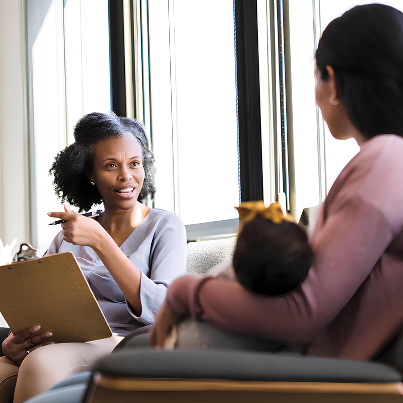 Counselor talking to mother holding baby