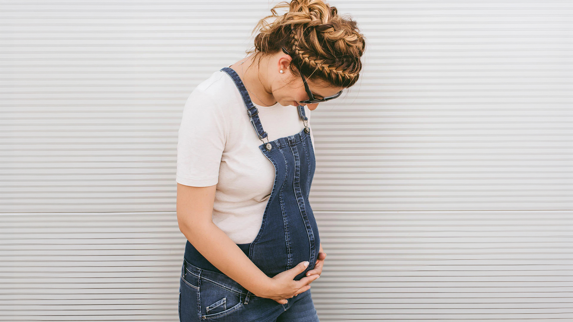 Pregnant woman smiling and holding her belly