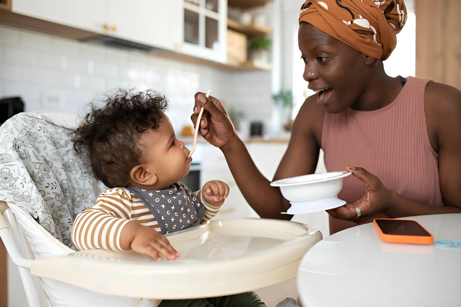 Mom feeding baby in high chair