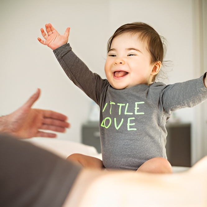 Smiling baby with arms raised joyfully