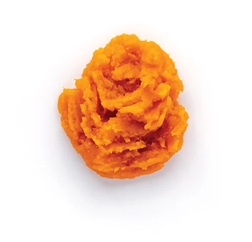 Mashed sweet potatoes with lumps on white background