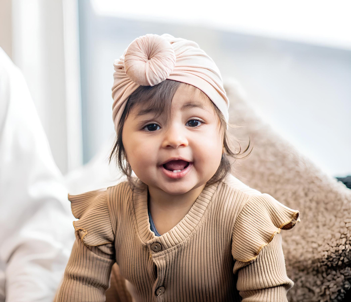 Smiling baby girl wearing a turban
