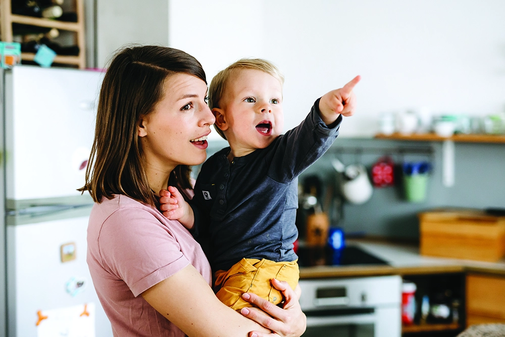 Mother holding child who is pointing excitedly