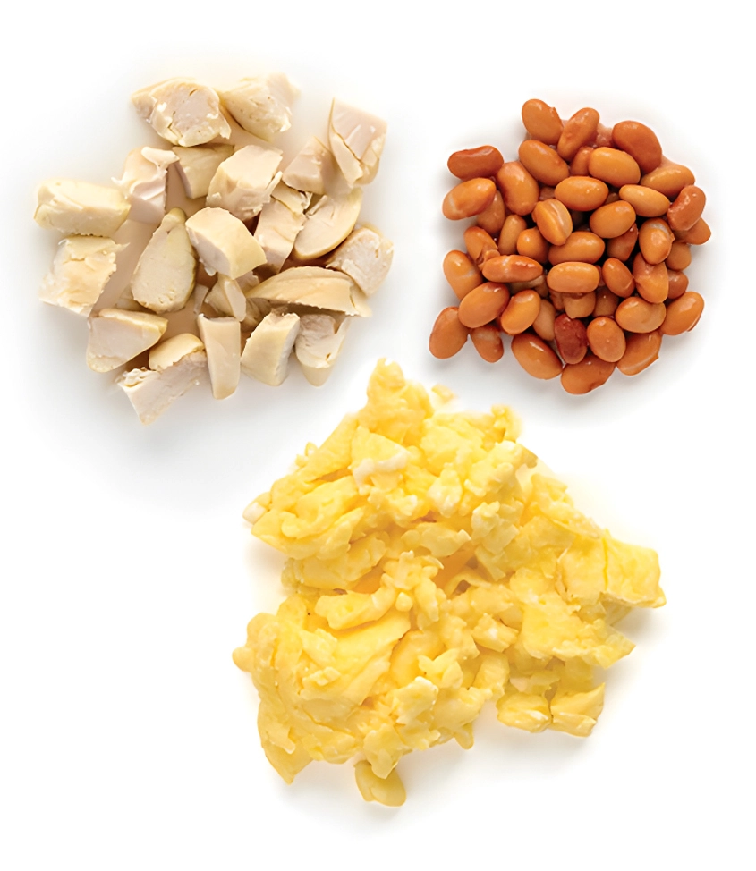 Diced chicken, beans, and scrambled eggs on white background