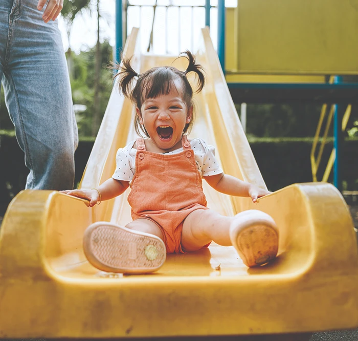 Baby girl playing on slide