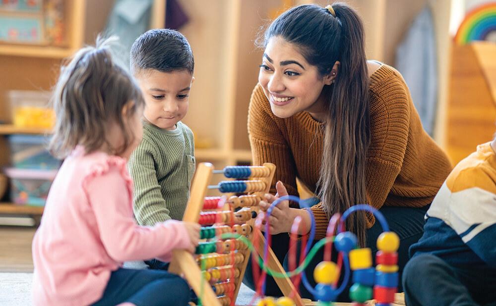 Teacher engaging with children playing with toys