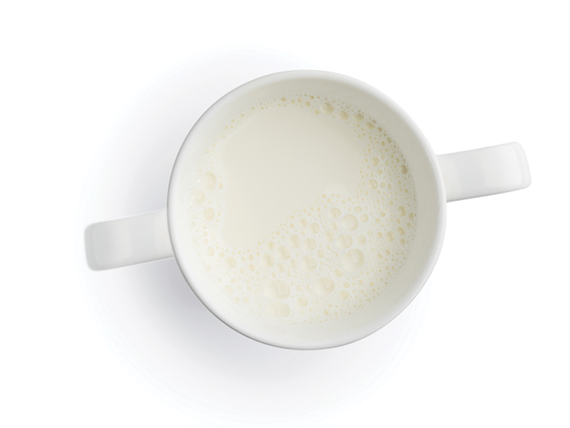 White cup filled with milk viewed from above